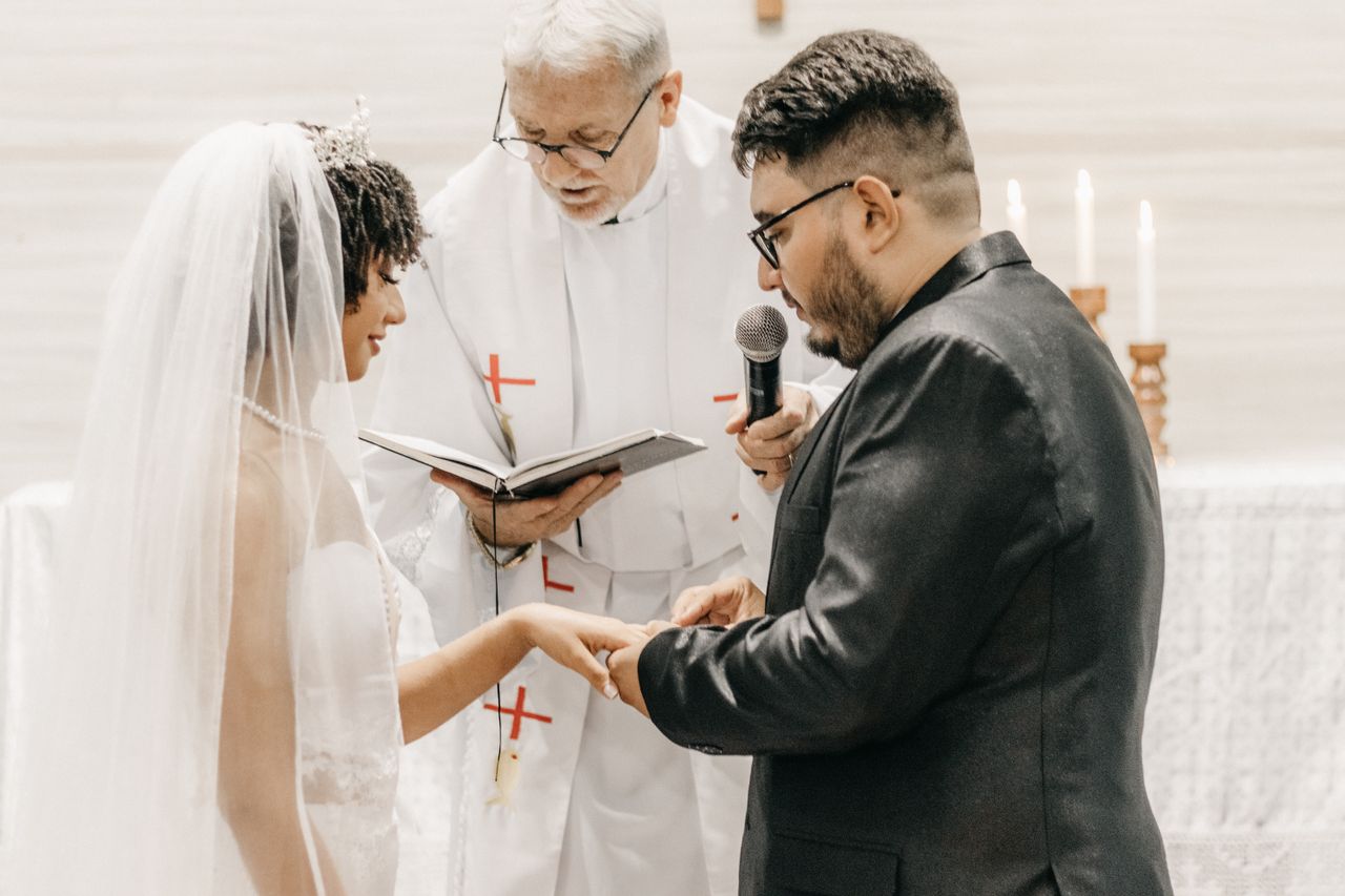 featured-images-02 Bride and groom exchanging vows in a church ceremony led by a priest.