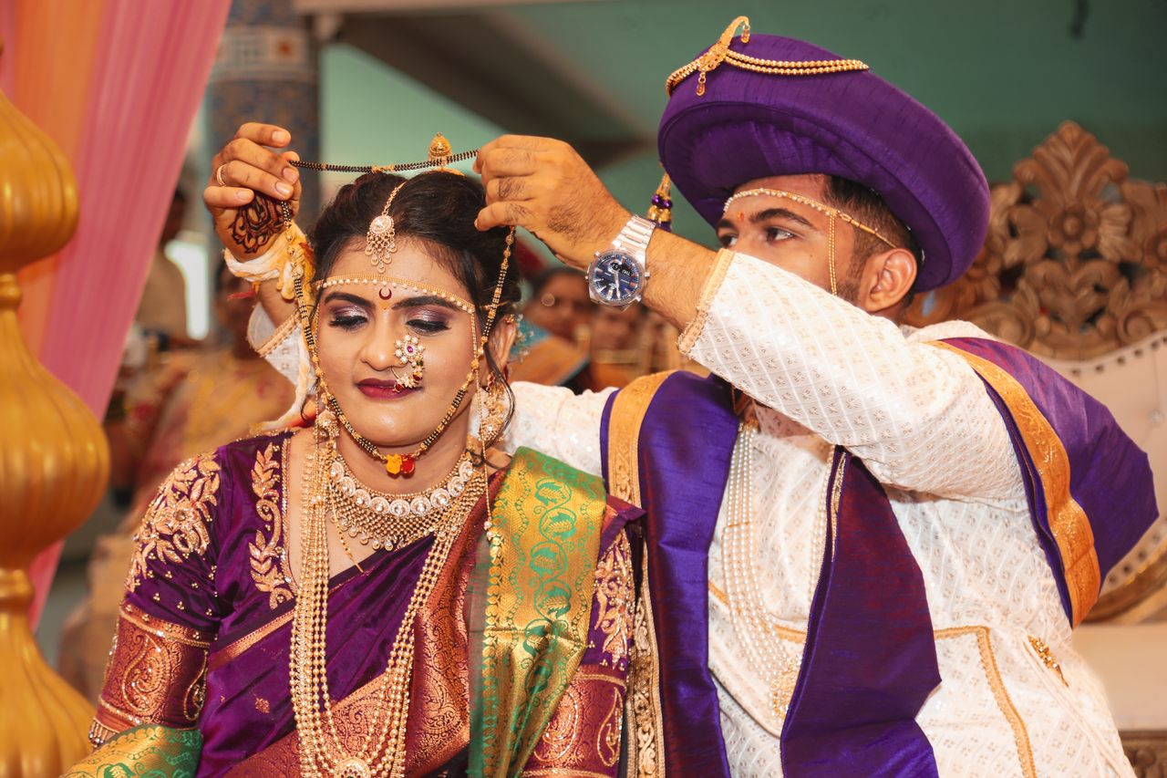 services-04 Bride and groom in traditional attire during an Indian wedding ceremony, exchanging jewelry.