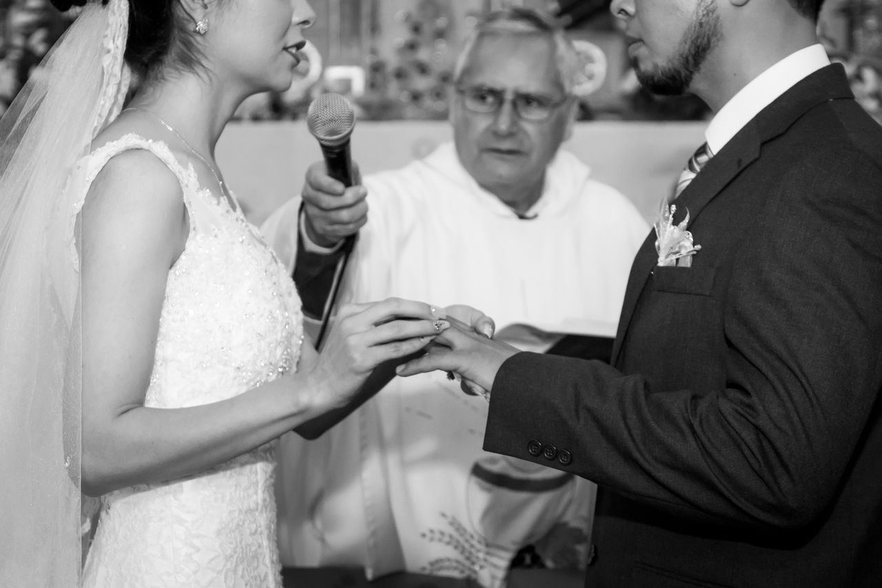 about-me-01 A monochrome image capturing a couple exchanging rings during their wedding ceremony.